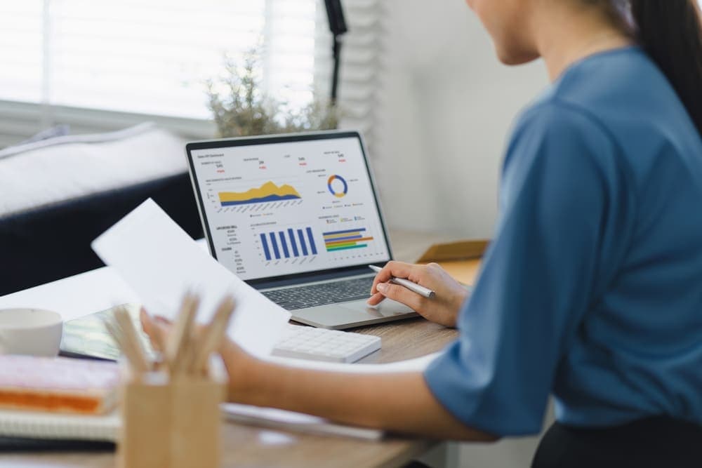 A woman working with CRM data on a laptop