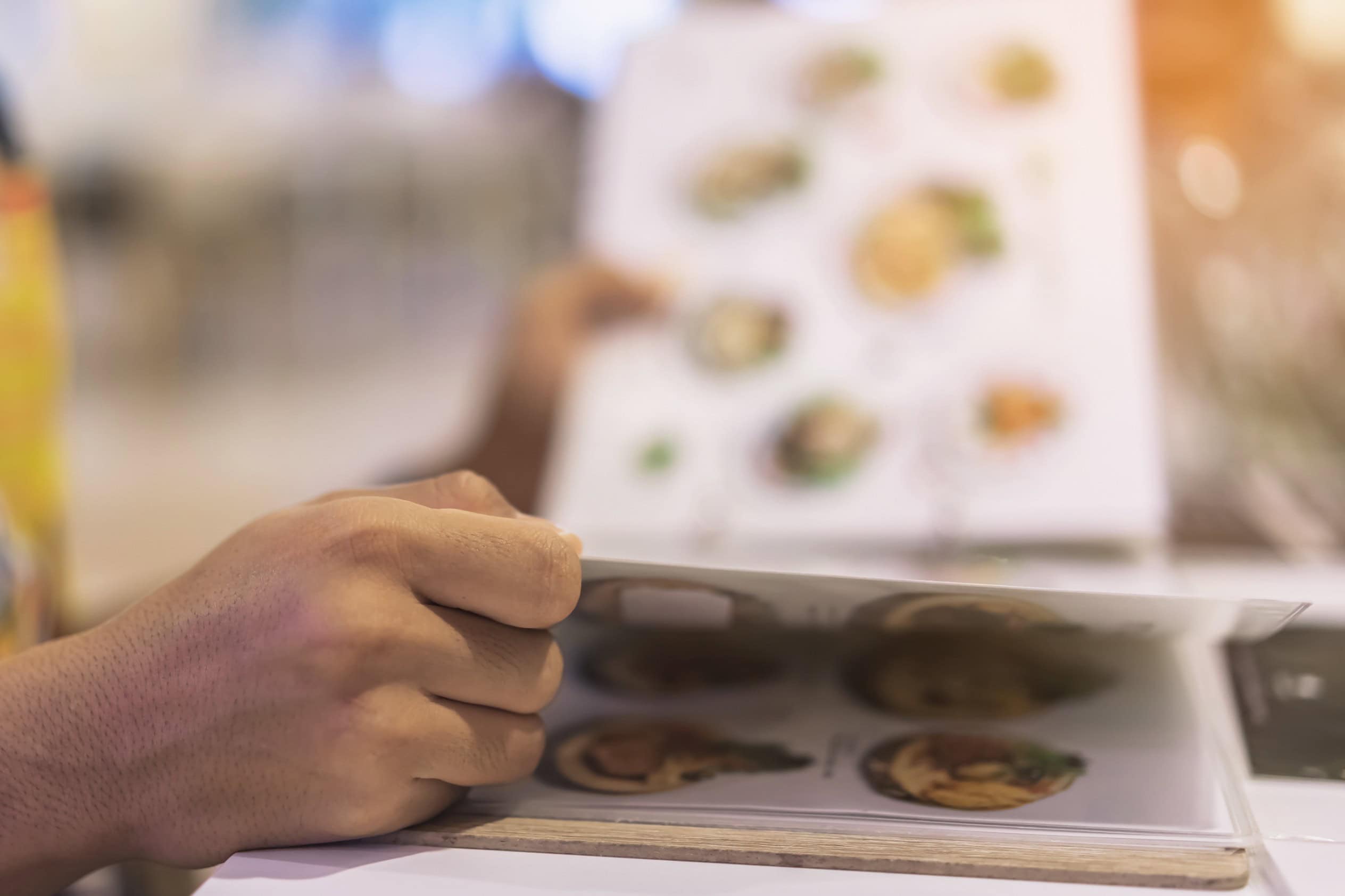 ลูกค้ากำลังเปิดเมนูอาหารที่ออกแบบตามหลักจิตวิทยา